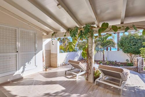 a patio with two chairs and a tree at Beach Villa - By Bobbywashere in Santa Maria
