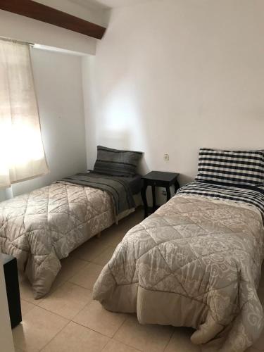 two beds sitting next to each other in a bedroom at Edelweiss, amplio departamento in Comodoro Rivadavia