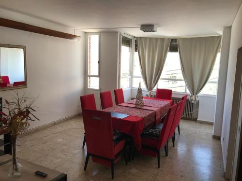 a dining room with a red table and red chairs at Edelweiss, amplio departamento in Comodoro Rivadavia