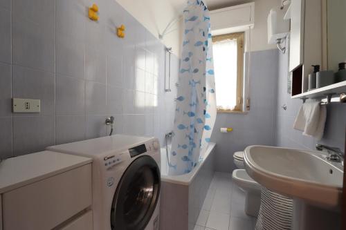 a bathroom with a washing machine and a sink at ModernShore - Garden Hideaway in Alba Adriatica