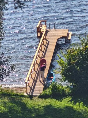 a man standing on a dock with a boat on the water at FerienWohnung SeeUfer am Plöner See in Ascheberg