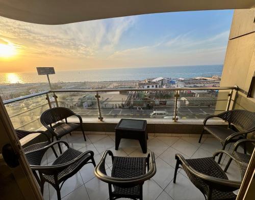 a balcony with chairs and a view of the ocean at ALEX HOMES - Gleem Luxury Apartments with Direct Sea View in Alexandria