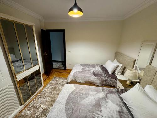 a bedroom with two beds and a mirror at ALEX HOMES - Gleem Luxury Apartments with Direct Sea View in Alexandria