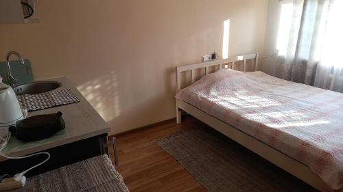 a small bedroom with a bed and a sink at MYROOM in Stroomi beach area in Tallinn
