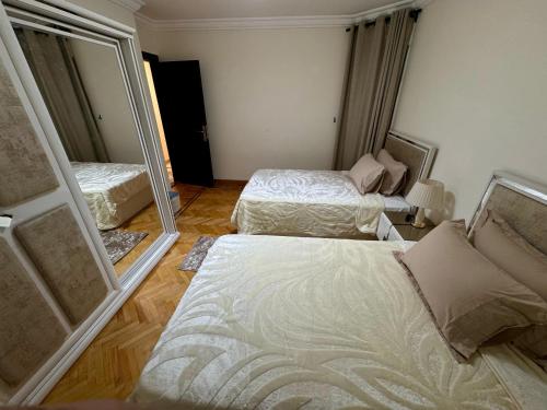 a bedroom with two beds and a large mirror at ALEX HOMES - Gleem Luxury Apartments with Direct Sea View in Alexandria