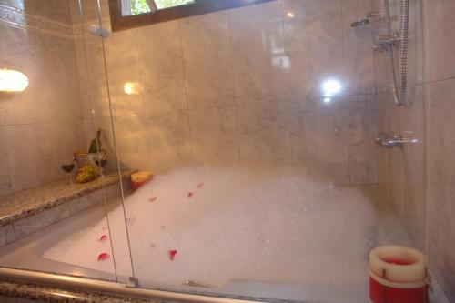 a bathroom with a shower with a tub with blood in it at Pousada Solar das Montanhas in Penedo