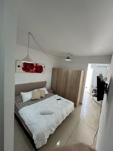 a bedroom with a bed with red roses on the wall at Elba Apartment in Msida