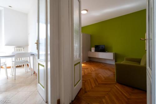 a living room with a green wall and a couch at Residenza Cece' in Lecco