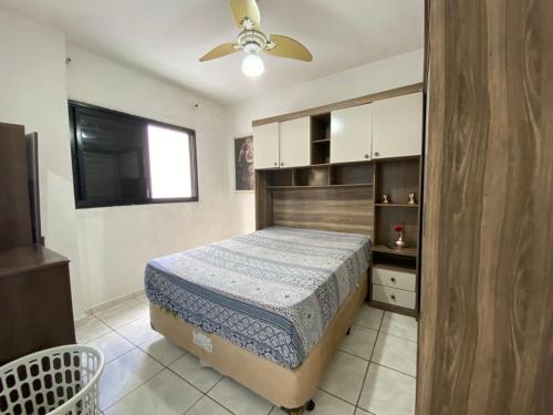 Un dormitorio con una cama y un ventilador de techo. en Apto 2min da praia Ocian! Perto da Estatua Netuno!, en Samaritá
