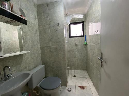 Un baño con ducha, inodoro y lavabo. en Apto 2min da praia Ocian! Perto da Estatua Netuno!, en Samaritá