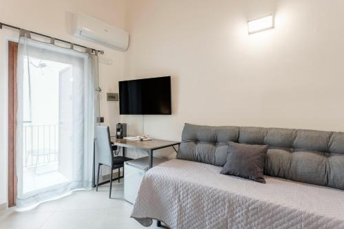 a bedroom with a bed and a desk and a television at La carbonaia rooms in Agrigento in Agrigento