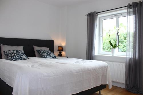 a bedroom with a white bed with a window at Badhusgatan 8 in Borgholm