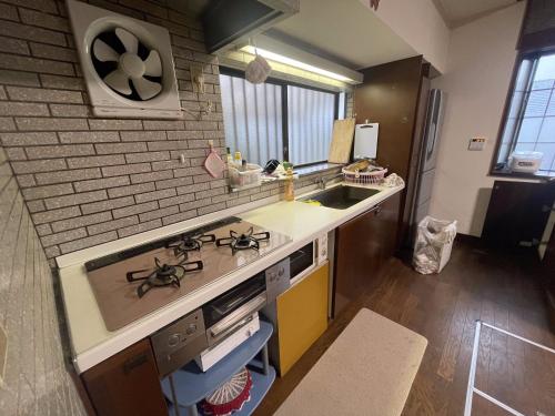 a kitchen with a sink and a stove top oven at 白浜荘Shirahamaso in Minamiboso