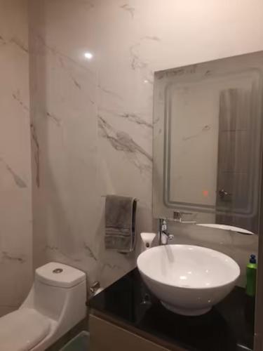 a white bathroom with a sink and a toilet at Departamento con Gran Vista in Monterrey
