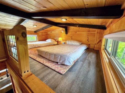 a bedroom with two beds in a log cabin at BMV6 Tiny Home Topline in Carroll