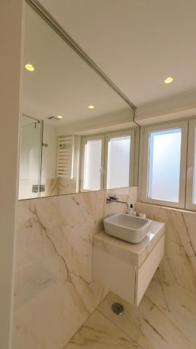 a white bathroom with a sink and a mirror at Saldanha cozy apartament in Lisbon