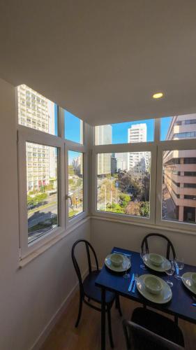 a dining room with a table and chairs and windows at Saldanha cozy apartament in Lisbon