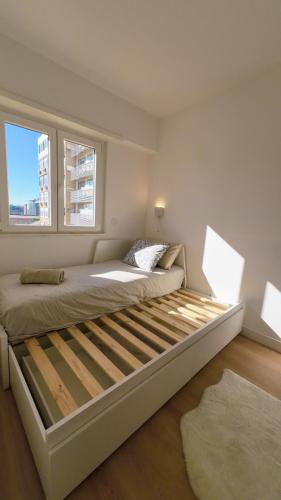 a large bed in a room with two windows at Saldanha cozy apartament in Lisbon