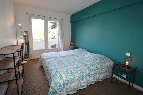 une chambre bleue avec un lit et une fenêtre dans l'établissement La Croix du Sud By Tranquil at Home, à La Baule