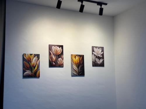 a group of four paintings on a wall at The Podium, Kuching in Kuching