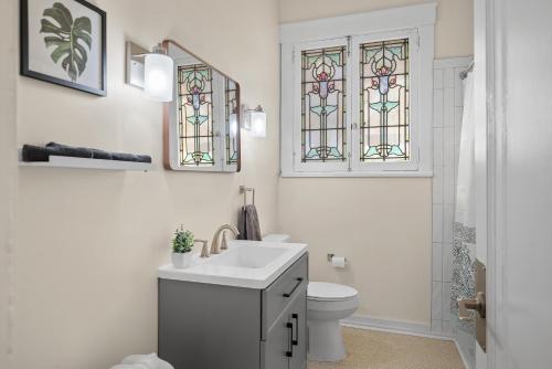 ein Badezimmer mit einem Waschbecken und einem WC mit Buntglas in der Unterkunft Unique Highland Park 2 Bdr Loft Sleeps 5 in Pittsburgh