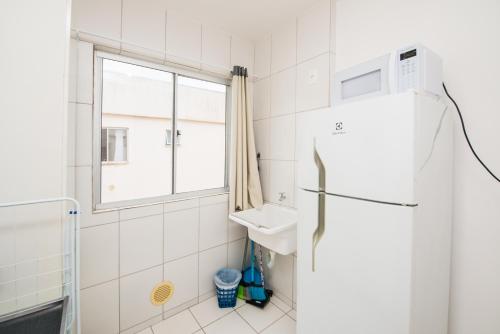 una cocina con nevera y ventana en Apartamento próximo a BR 101 ideal para viajantes, en Palhoça