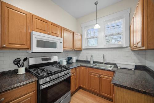 a kitchen with a stove and a microwave at Unique Highland Park 2 Bdr Loft Sleeps 5 in Pittsburgh