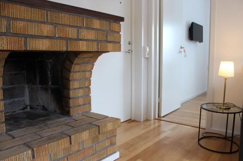 a living room with a brick fireplace with a lamp at Badhusgatan 8 in Borgholm