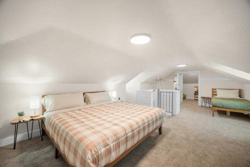 ein weißes Schlafzimmer mit einem Bett und einer Treppe in der Unterkunft Unique Highland Park 2 Bdr Loft Sleeps 5 in Pittsburgh