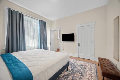 a bedroom with a bed and a flat screen tv at Unique Highland Park 2 Bdr Loft Sleeps 5 in Pittsburgh