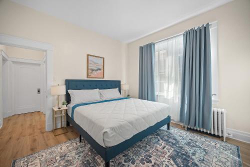 a bedroom with a blue bed and a window at Unique Highland Park 2 Bdr Loft Sleeps 5 in Pittsburgh