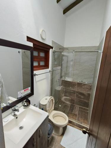a bathroom with a toilet and a sink and a shower at Hotel San Luis Sachica ng in Sáchica
