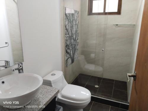 a bathroom with a toilet and a sink and a shower at Hotel San Luis Sachica ng in Sáchica