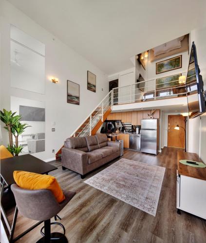 an open living room with a couch and a staircase at Two-Story Loft with a High-rises view and Rooftop Deck in Vancouver