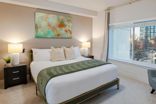 a bedroom with a large bed and a window at Convention Ctr Bespoke Beauty - 2BD Pool,Gym,Hot tub,Pkg in Salt Lake City