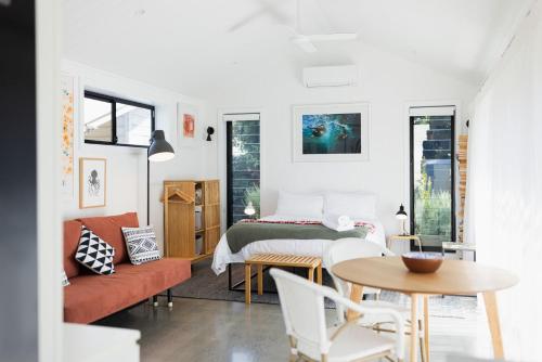 a living room with a bed and a table at Ro-ana for 8, Gerringong in Gerringong