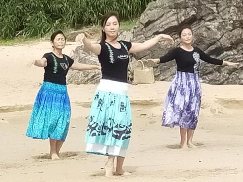 three women are standing on the beach at 奄美大島 龍郷町 体験の宿 こうりゅう館 in Tatsugo