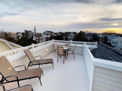 a balcony with chairs and a table on a roof at Single Family Ship Bottom Wifi Beach Badges Decks Air Conditioning Granite Countertops Recently Renovate Single Family House In Ship Bottom in Ship Bottom