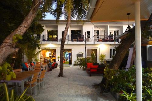 a resort with chairs and tables and palm trees at Maamadi Boutique in Maafushi