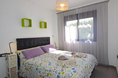 a bedroom with a bed with towels on it at Magnifico apartamento en Oasis Beach in Playa Flamenca