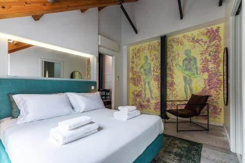 リスボンにあるPortas do Céu Apartmentsのタオルが敷かれた白いベッドのある寝室