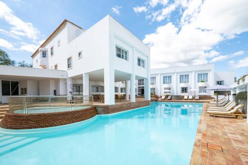 a swimming pool in front of a white building at Baluarte da Vila Apartments in Lagos