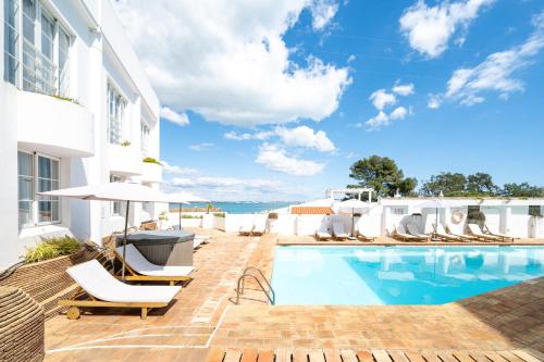 a swimming pool next to a white building at Baluarte da Vila Apartments in Lagos