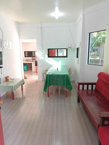 ein Wohnzimmer mit einem Tisch und einer roten Couch in der Unterkunft Vincent and Rose Home stay in Maricaban