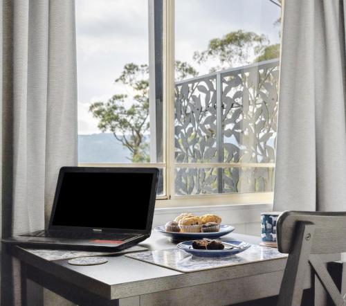 a laptop sitting on a table in front of a window at Bulga Amaroo in Bilpin