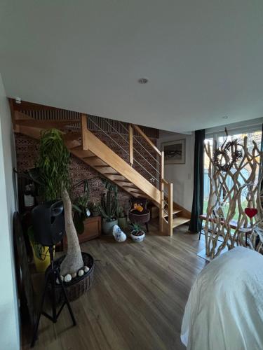 une chambre avec un escalier et des plantes en pot dans l'établissement la maison de Etienne, à Chaux
