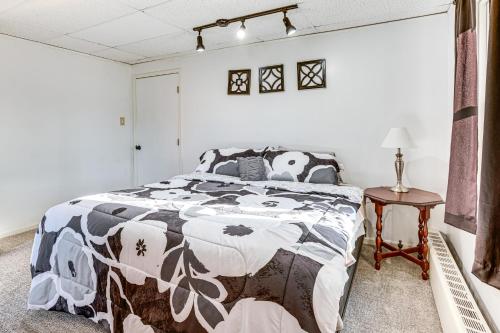 a bedroom with a black and white comforter on a bed at 1 Block to Crystal Lake Downtown Beulah Apt! in Beulah