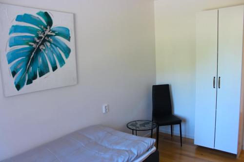 a bedroom with a bed and a black chair at Badhusgatan 8 in Borgholm
