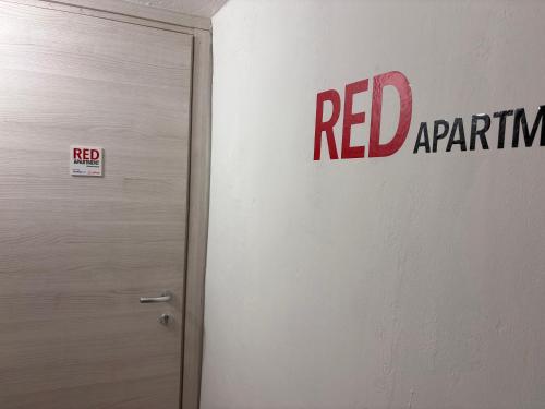 un letrero de aparato rojo en una pared junto a una puerta en Red appartament, en Bagnolo Piemonte