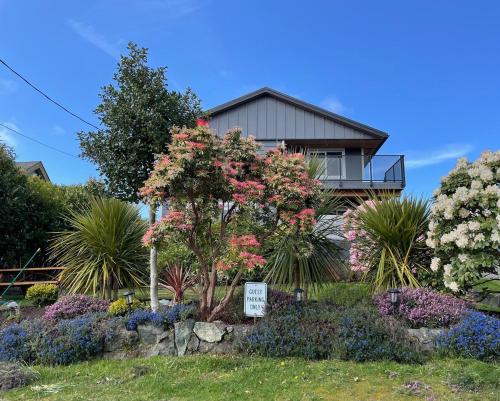 a house with a sign in front of a garden at Sea Breeze Suite - Centrally Located in Ucluelet in Ucluelet